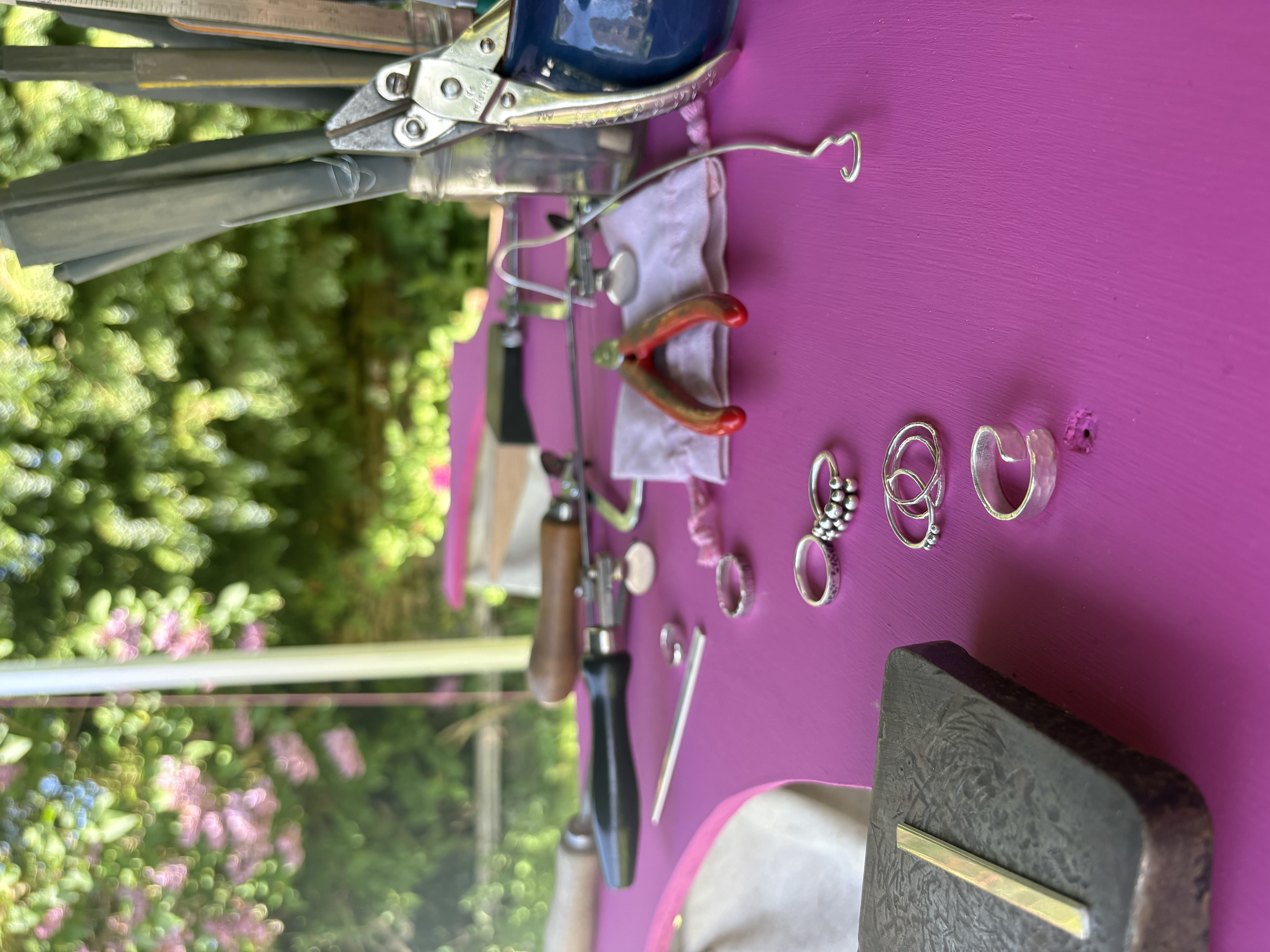 Finished sterling silver rings laid out on the workshop table